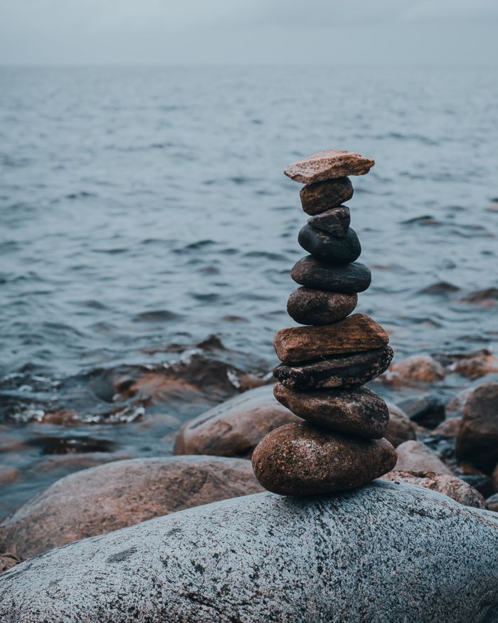 The Art of Drawing Readers In: Your attractive post title goes here A serene stack of stones on the rocky beach by the ocean, symbolizing balance.